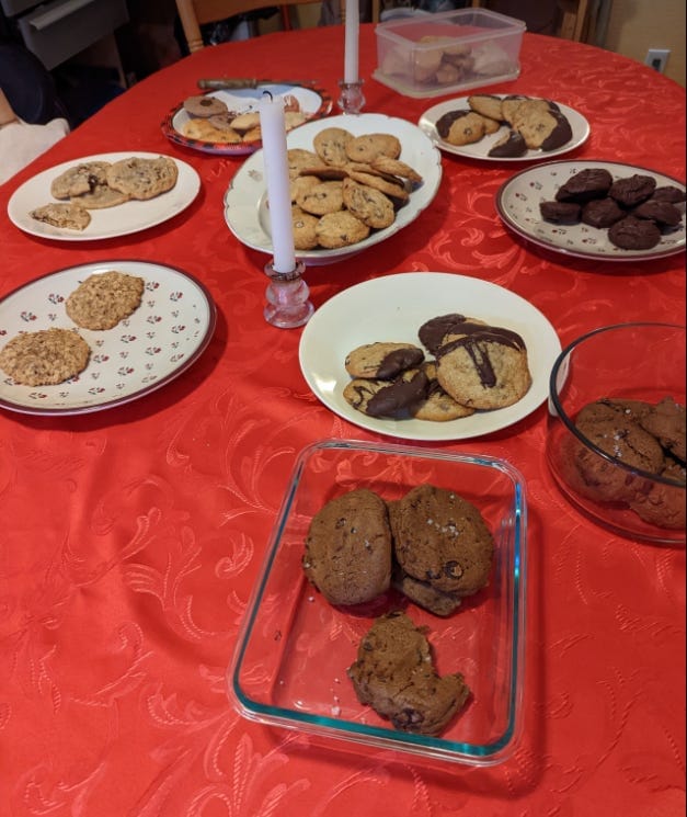 A table on which are many plates heaped with different cookies